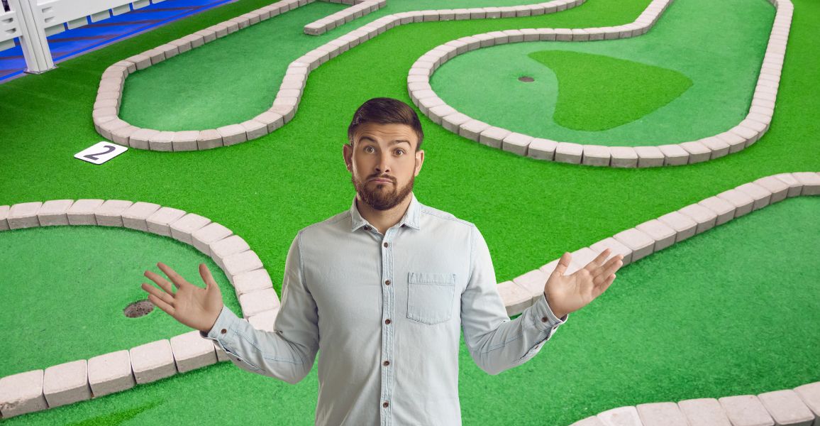 Man shrugging as he doesn't know if mini golf is difficult